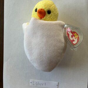 Beanie Baby Eggbert is about 5 inches tall, a product of Ty is yellow in a shell